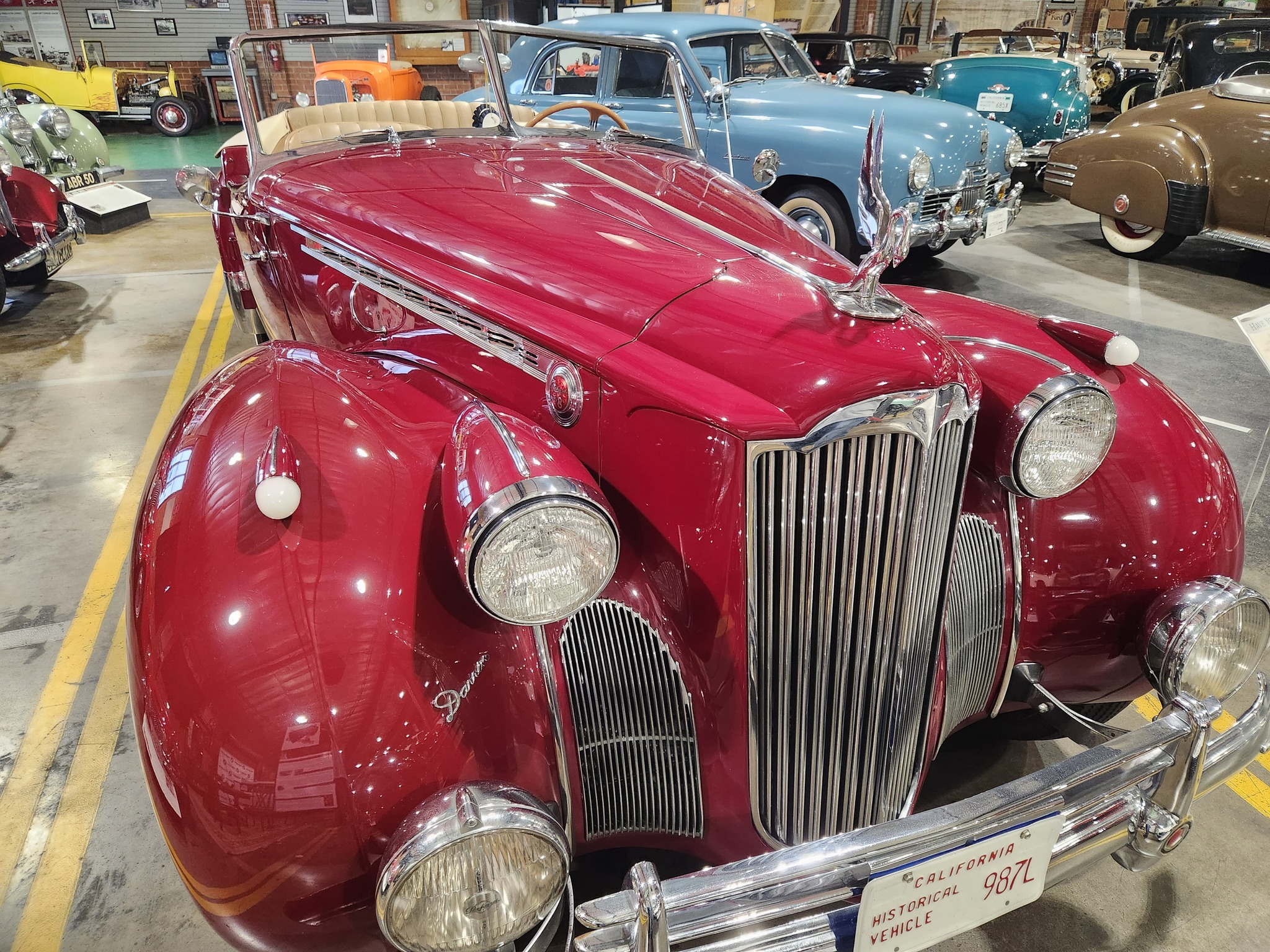 Red classic car in garage with other classic cars