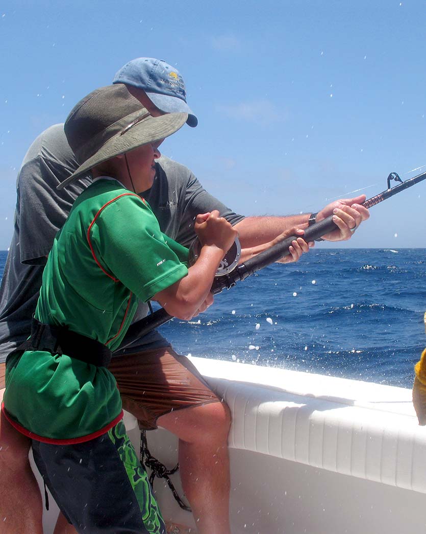 dad teaching young boy how to fish