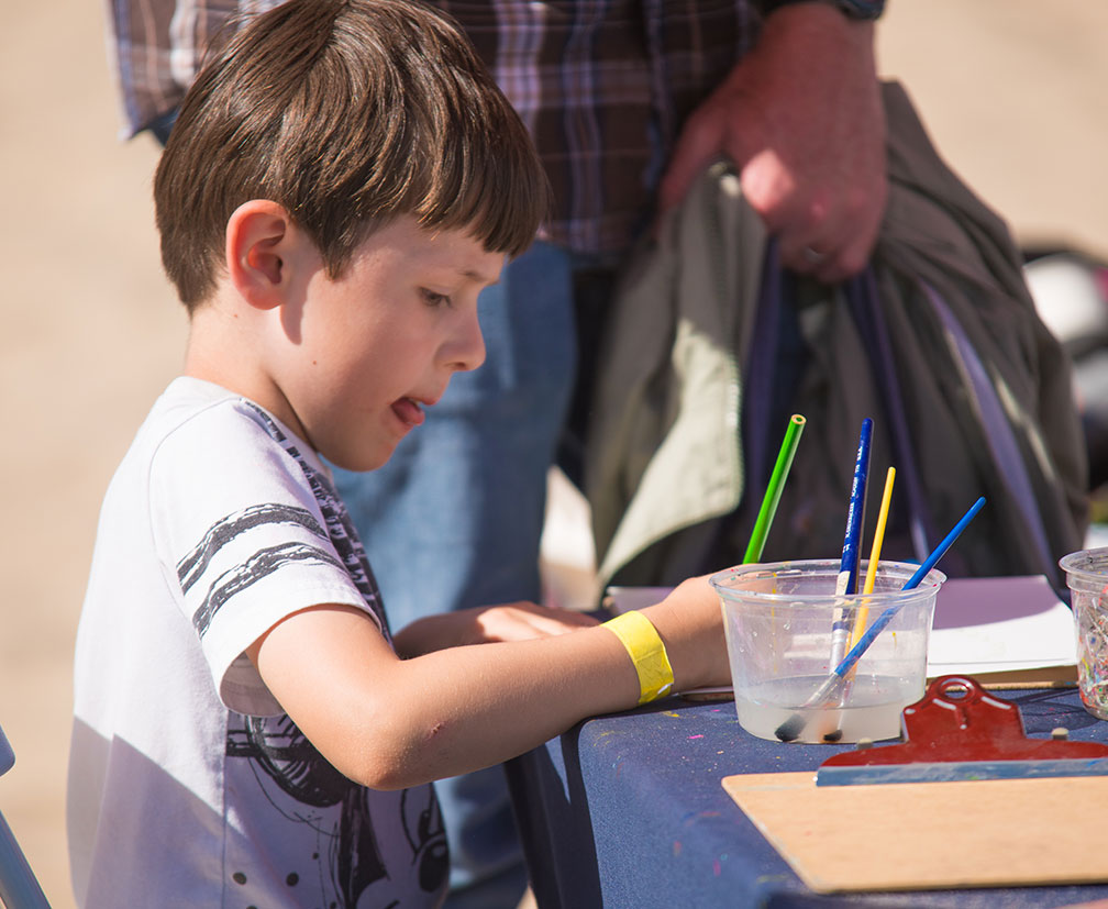 kid holding green pencil and painting at artsea in marina del rey