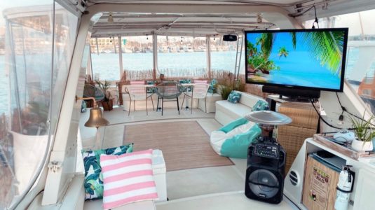 Interior couch with TV of a boat docked in the water